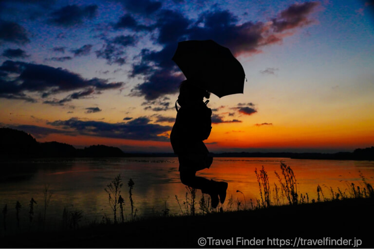 伊豆沼で撮影したシルエット写真です。傘を持ってジャンプ！